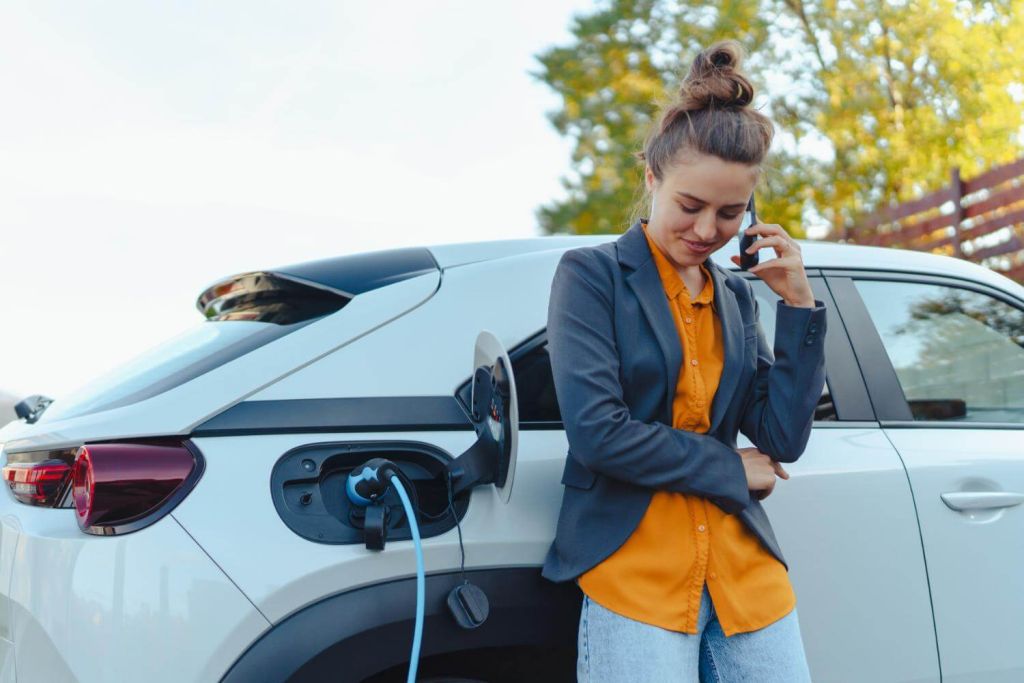 women callling in front of ev car